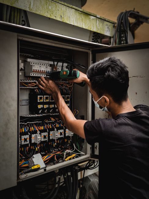 Électricien de Richard Garrett Électrique au travail sur un panneau électrique
